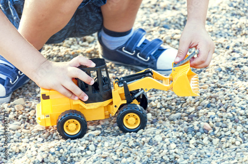 Kid plays with toy excavator