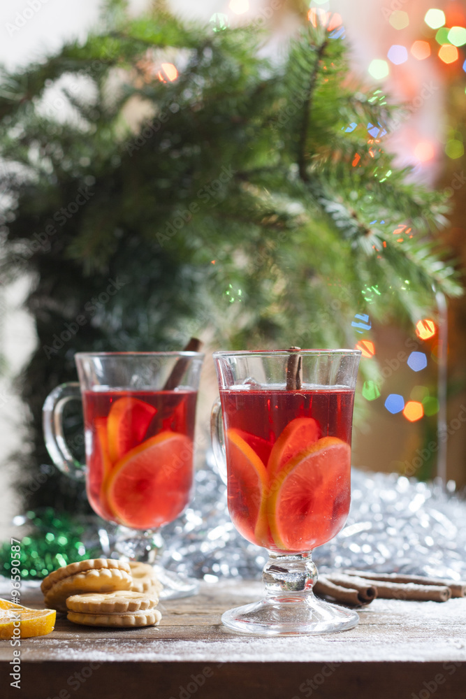 Tea with lemon, tangerines, cookies and nuts in Christmas decor with Christmas tree, nuts and apples on colorful background bokeh Tea with lemon, tangerines, cookies and nuts in Christmas decor with Christmas tree, nuts and apples on colorful background bokeh
