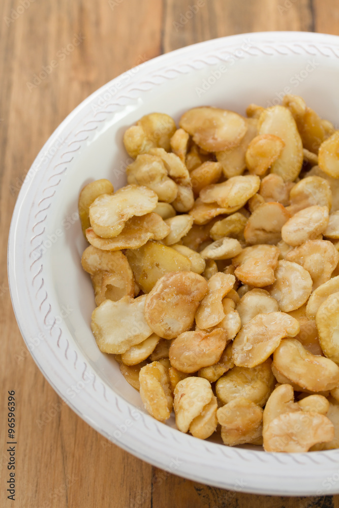 fried beans in white bowl on brown background fried beans in white bowl on brown background