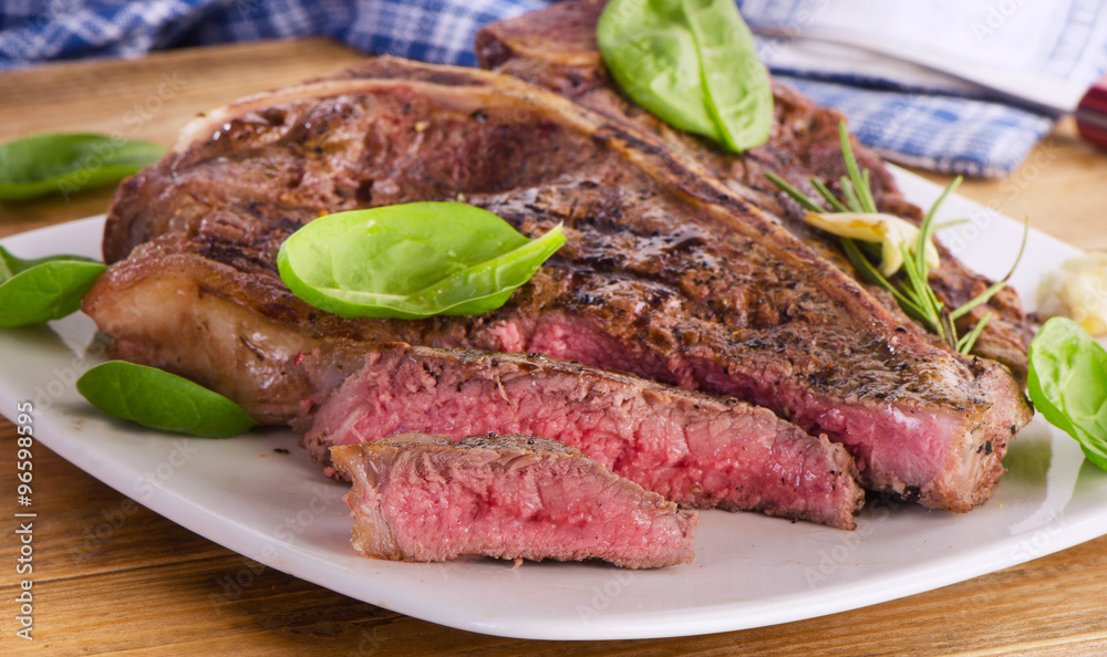 Beef steak served with  fresh green salad.