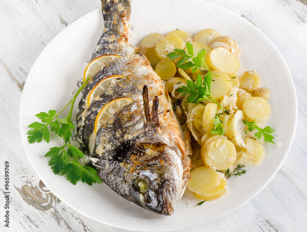Fried fish with potatoes,fresh herbs and lemon. Fried fish with potatoes,fresh herbs and lemon.