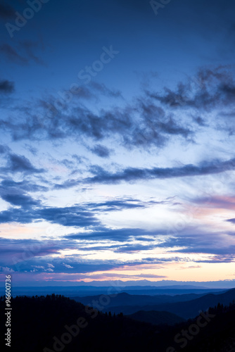 panoramic view of a series of hills of the Valsesia (Piedmont, Italy) at sunset with blue and pink clouds.