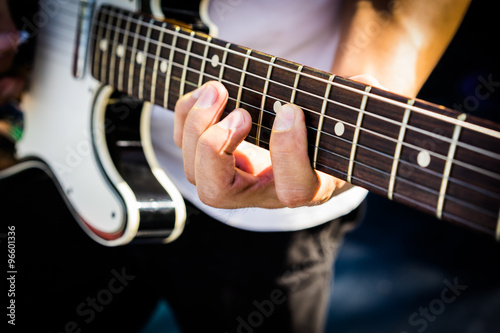 Hand of the Guitarist on electric guitar fingerboard