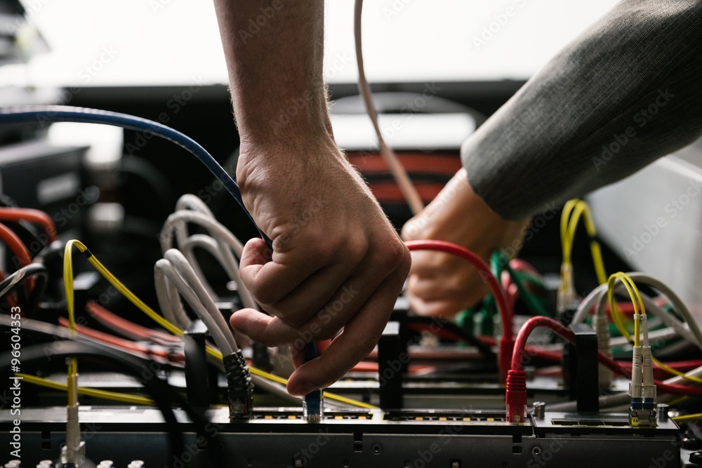 Team of technicians working together on servers Team of technicians working together on servers