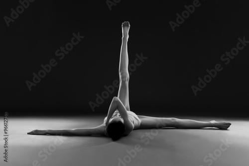 Naked yoga. Beautiful sexy body of young woman on gray background photo
