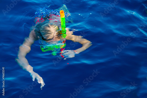Cute girl snorkeling in water mask
