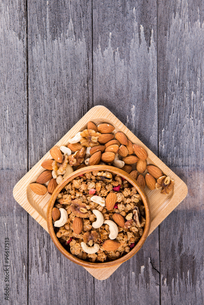 Bowl of breakfast muesli mixed with dried fruit and nuts in a wo Bowl of breakfast muesli mixed with dried fruit and nuts in a wo