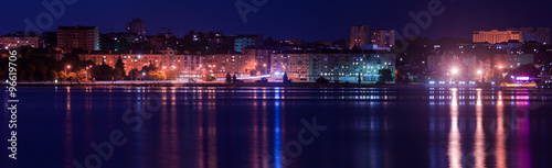 Panorama night city with reflection in the water. Europe, Ukrain