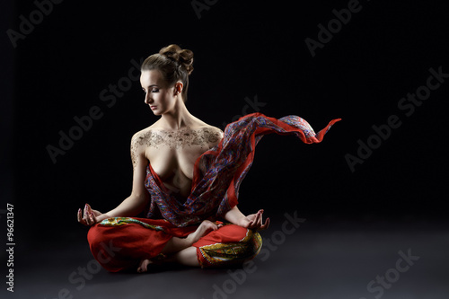 Yoga. Sensual woman meditating in lotus position photo