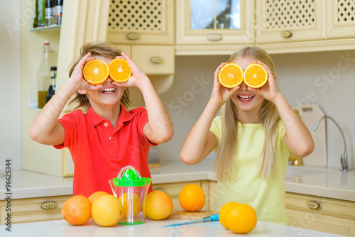Funny teenagers with citrus. Boy and girl holding fruit oranges