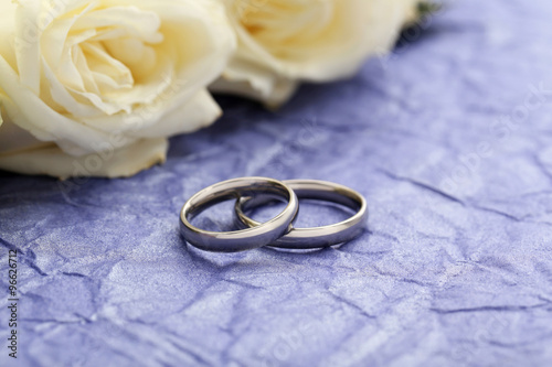Silver wedding rings on a purple paper background
