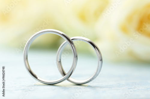 Fotografie Silver wedding rings on a blue wooden table