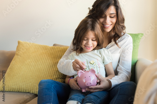 Mom and daughter saving money photo