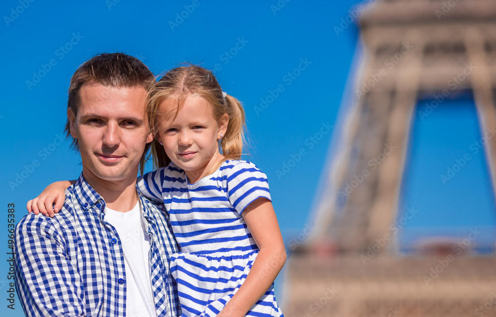 Happy father and little adorable girl in Paris near Eiffel Tower during summer french vacation