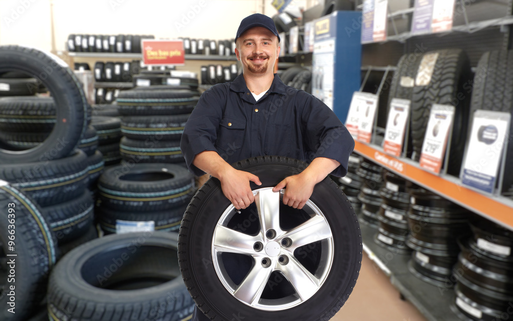 Car mechanic with a tire. Car mechanic with a tire.