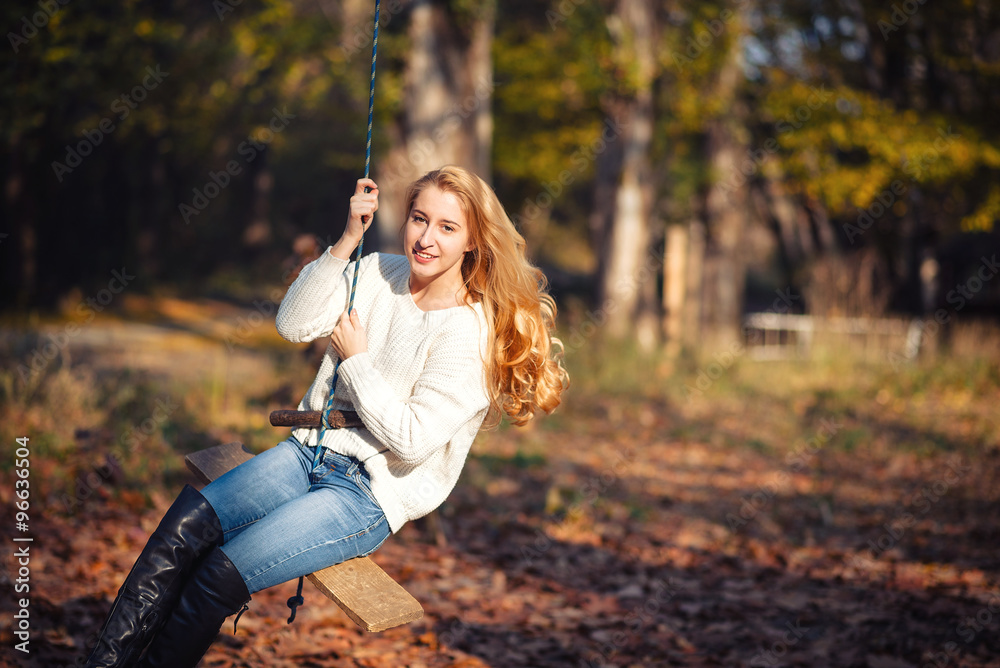 Two happy and cheerful young girl students, blond and brunette in coat and jeans laughing in sunny autumn park full of fallen leaves, horizontal pictures Two happy and cheerful young girl students, blond and brunette in coat and jeans laughing in sunny autumn park full of fallen leaves, horizontal pictures