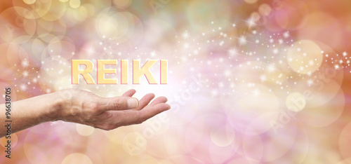 Fototapeta Naklejka Na Ścianę i Meble -  Golden Reiki Healing Energy Share    - Female with outstretched hand palm facing up and the word 'REIKI' hovering above  on an ethereal golden bokeh and sparkles background and white light
