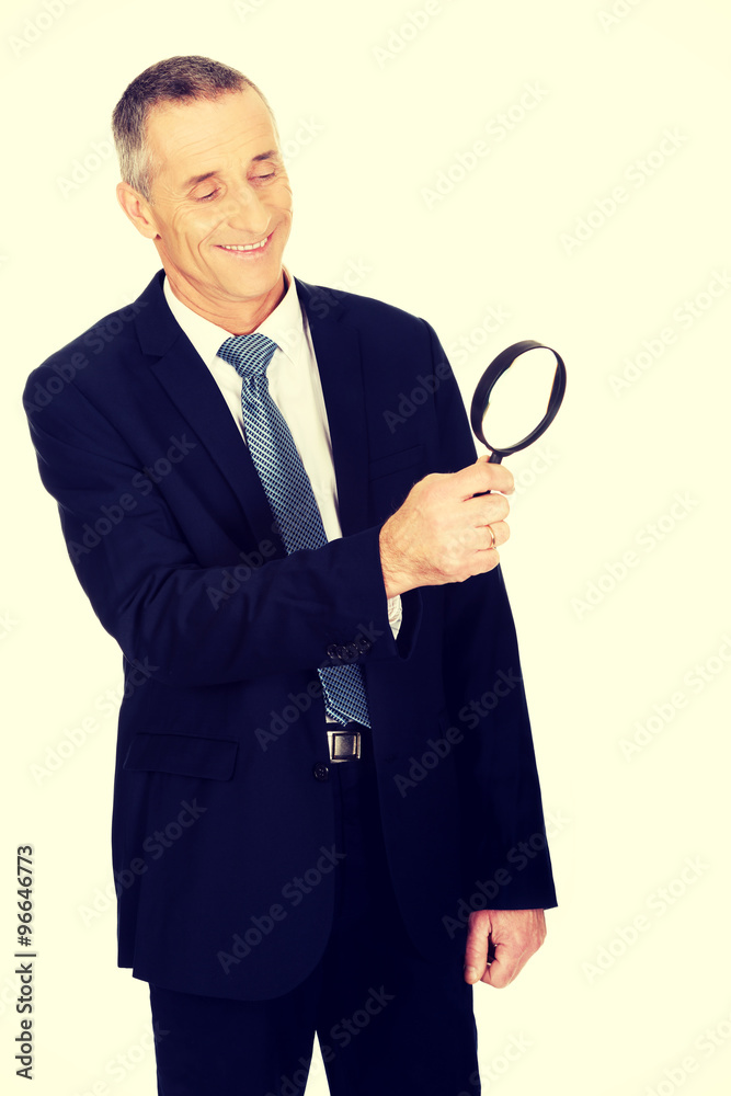 Businessman looking through a magnifying glass Businessman looking through a magnifying glass