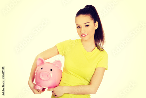 Happy woman holding piggybank.