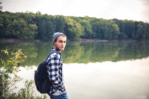 Young Man standing alone outdoor Travel Lifestyle concept with lake © serbogachuk