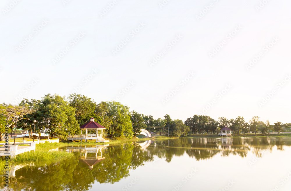 Obraz premium outdoor public park view in evening with pavilion beside the pon