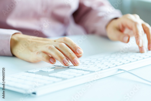 Woman office worker typing on the keyboard