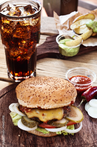 Burger with cola on a wooden table