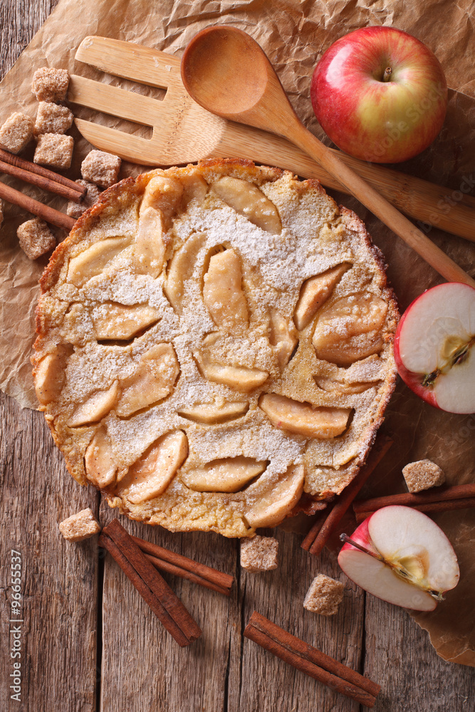 Fototapeta premium Dutch baby pancake with apple on a paper closeup. Vertical top view