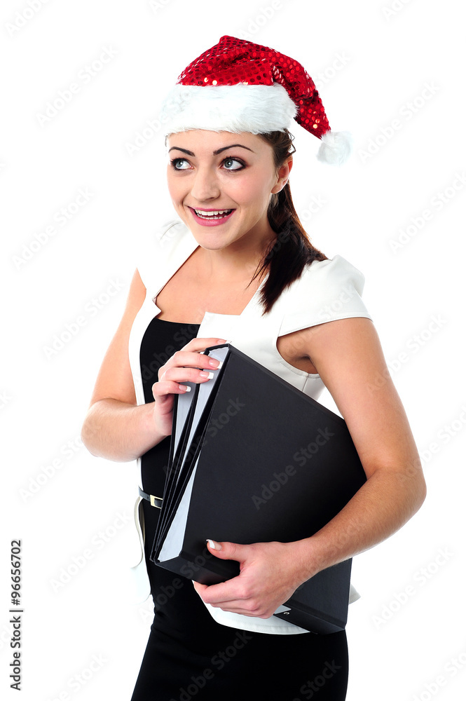 Female employee holding files wearing santa cap Female employee holding files wearing santa cap