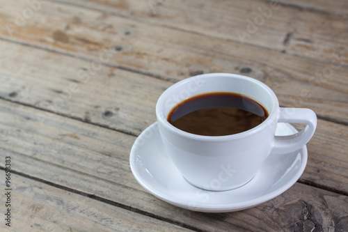 White cup of coffee on wood background