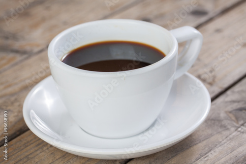 White cup of coffee on wood background