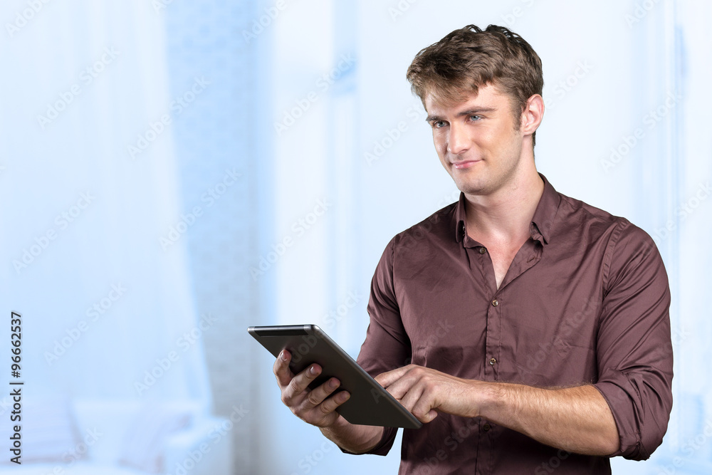 Smiling young man using tablet computer Smiling young man using tablet computer