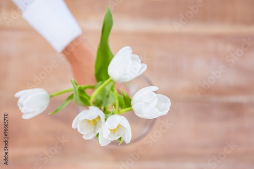 Fototapeta Naklejka Na Ścianę i Meble -  Woman putting a flowers in a vase