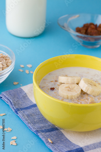 Breakfast porridge with bananas and raisins, vertical view