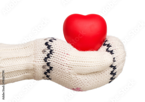 Winter  little girl s hand holding rubber heart isolated on white