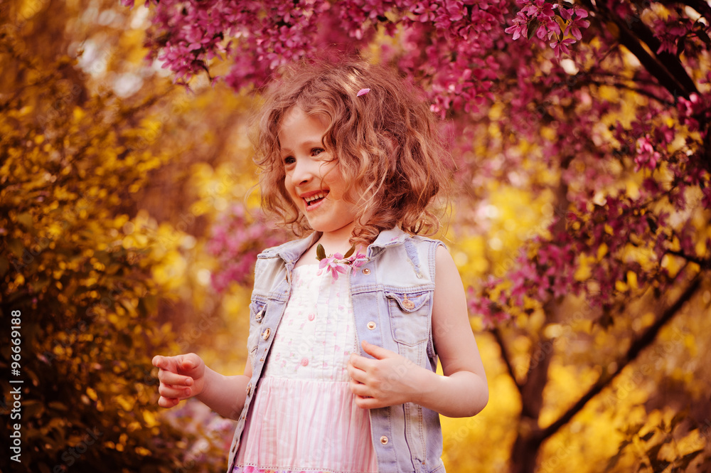happy child girl in pink dress playing outdoor in spring garden near blooming crabapple tree happy child girl in pink dress playing outdoor in spring garden near blooming crabapple tree
