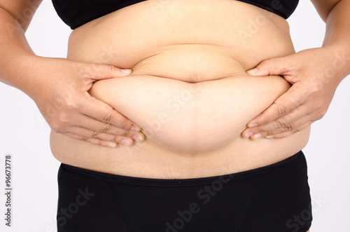 Woman's fingers measuring her belly fat
