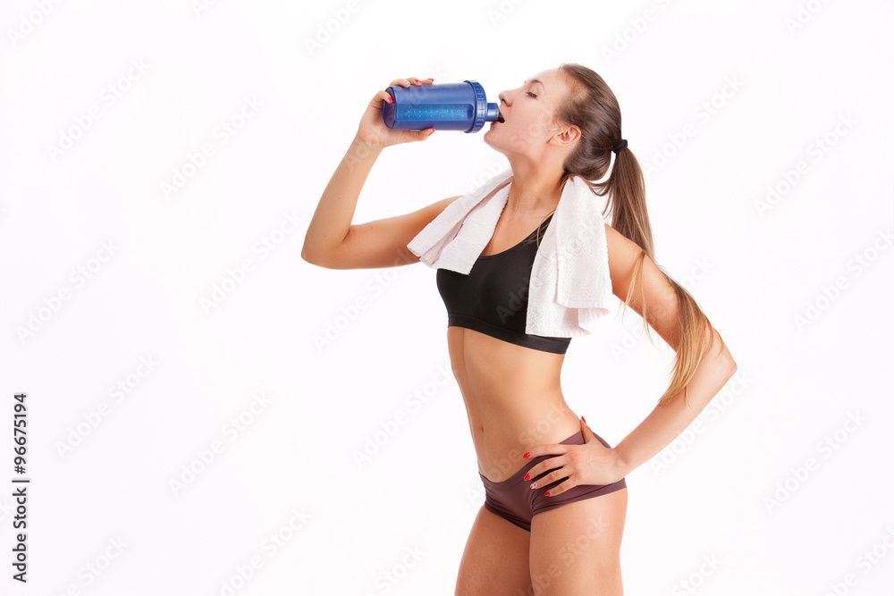 sporty muscular woman drinking water, isolated against white bac sporty muscular woman drinking water, isolated against white bac