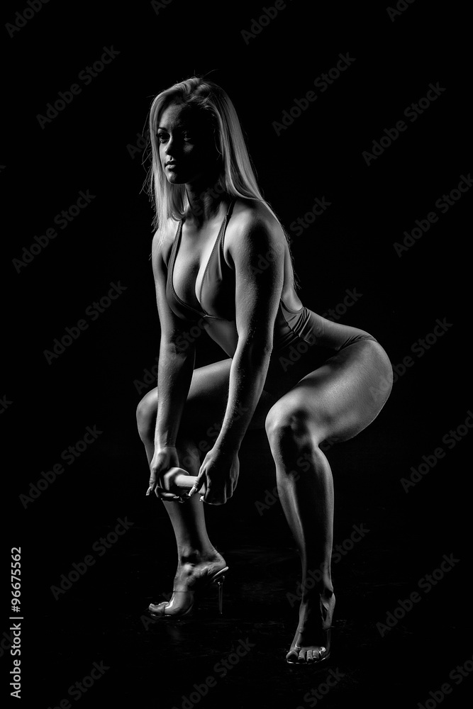 Sexy athletic woman working out with dumbbells