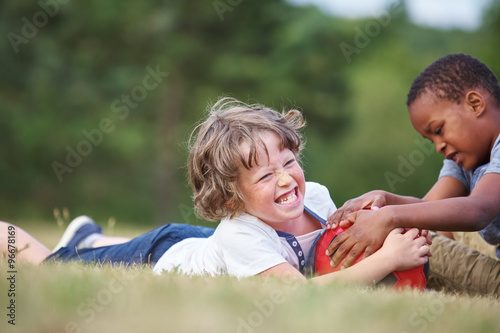Zwei Jungen mit einem Fußball im Gras photo