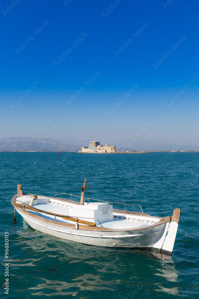 Seascape with fishing boat and Bourtzi castle in background, Nafplio, Greece