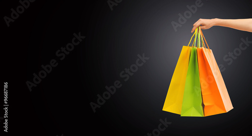 close up of hand holding shopping bags