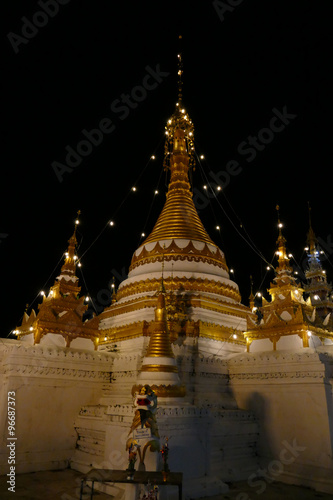 white and golden buddhist pagoda monument at night