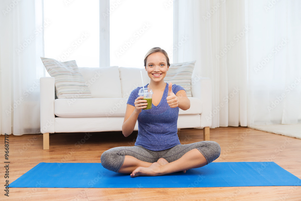 woman with smoothie showing thumbs up at home woman with smoothie showing thumbs up at home
