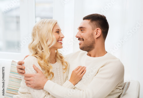 happy couple hugging on sofa at home