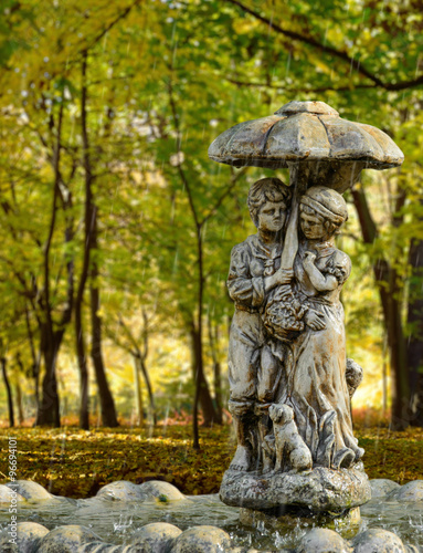 Young couple under an umbrella in the park