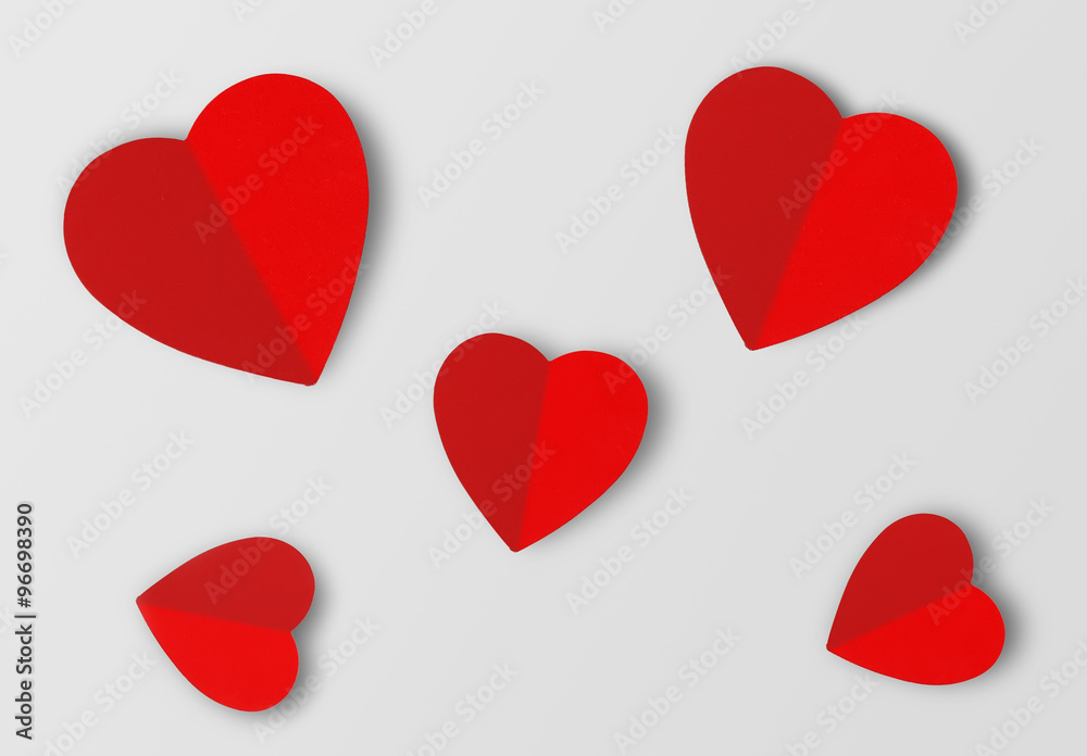 Beautiful paper hearts on grey paper background, close-up Beautiful paper hearts on grey paper background, close-up