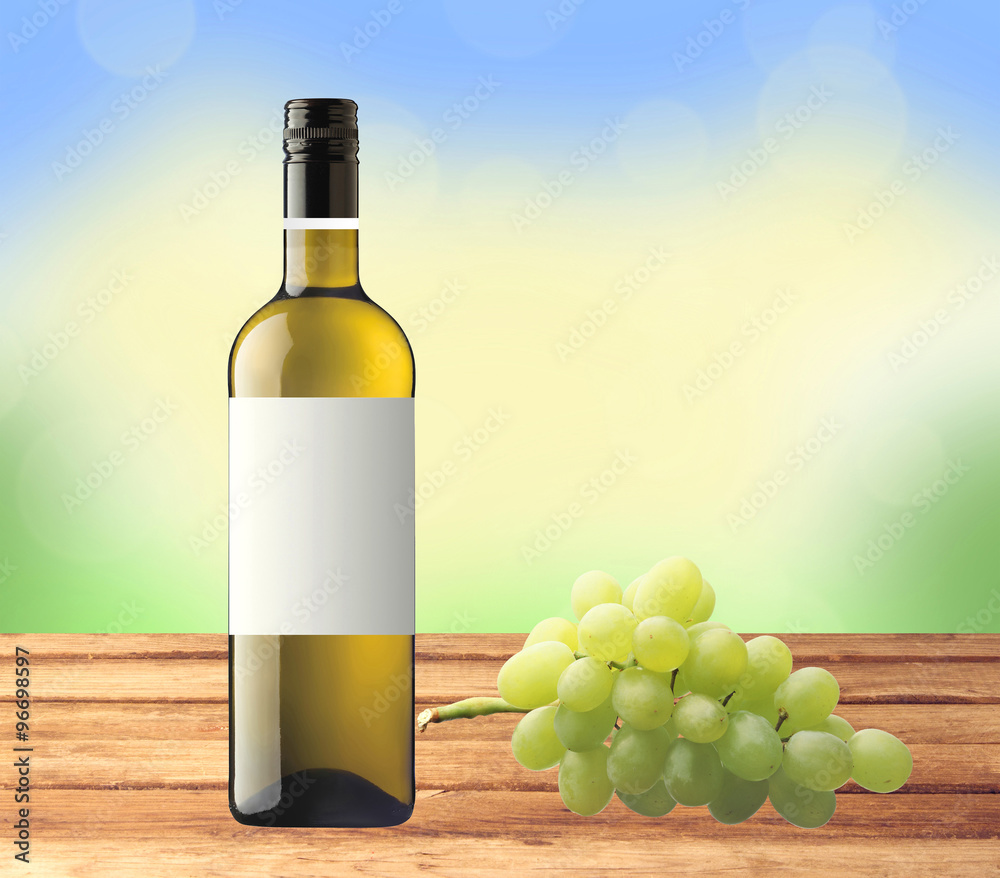 bottle white wine and green grape on wooden table over nature ba