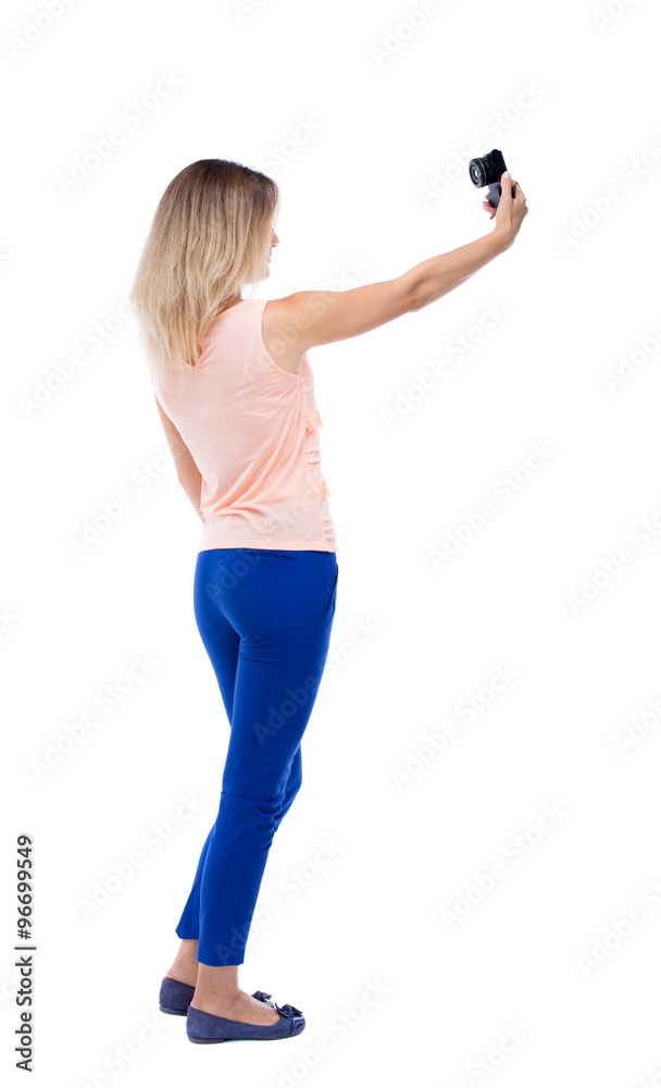 back view of standing young beautiful woman and using a mobile back view of standing young beautiful woman and using a mobile