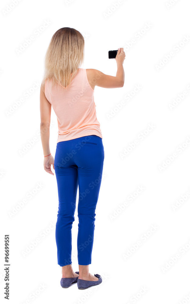 back view of standing young beautiful woman and using a mobile back view of standing young beautiful woman and using a mobile